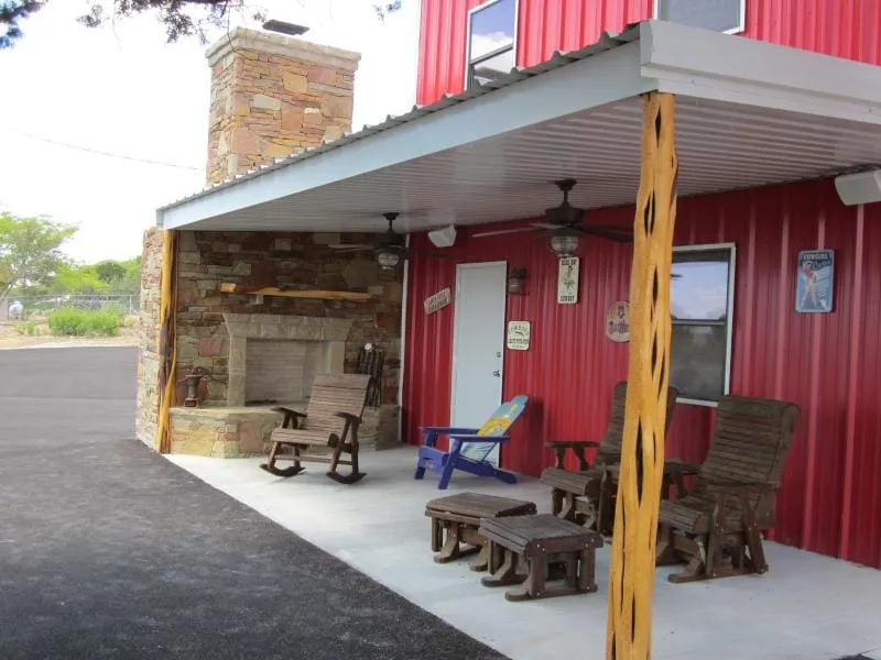 Covered outdoor patio with stone fireplace at the red shop home.