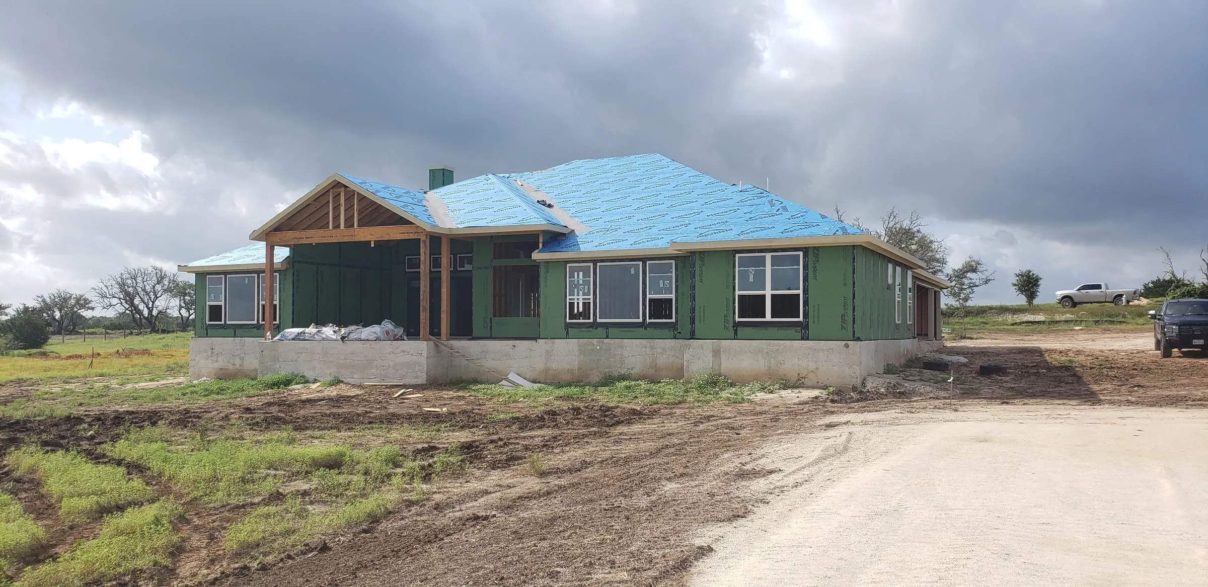 Home wrapped in sheathing with the roof deck installed.