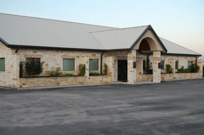Stone professional office complex with white metal roof.