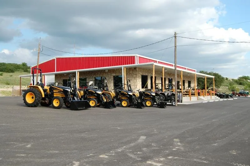 Side elevation of the Hoffpauir Outdoor Super Store with red trim and gated yard.