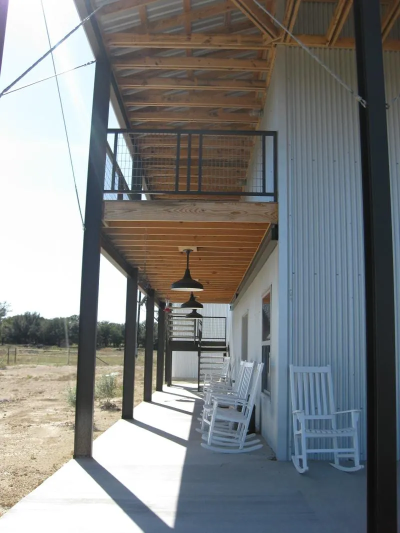 Steel-framed porch with wood ceiling and rocking chairs.