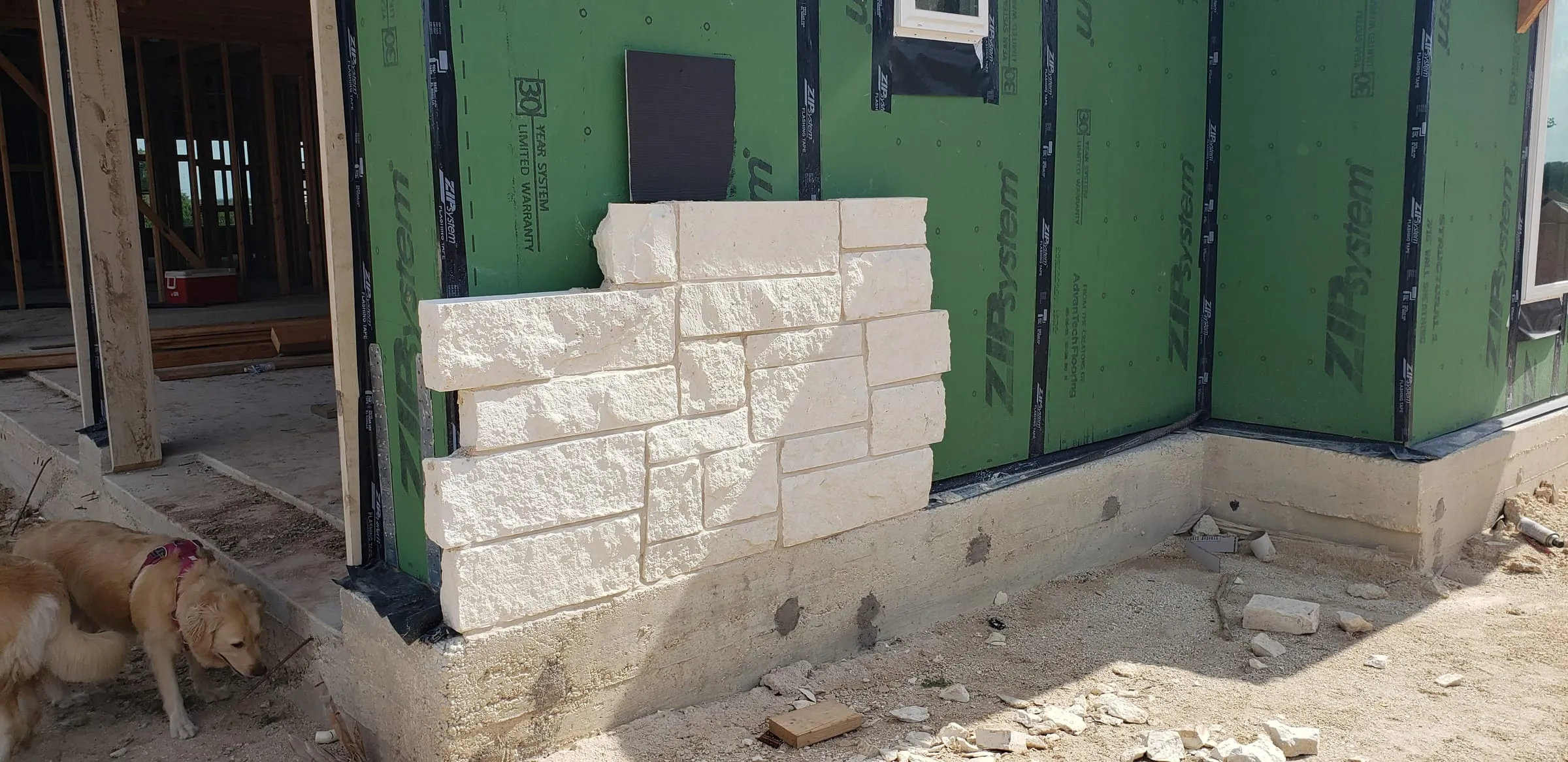 Limestone veneer going up over the weather barrier.