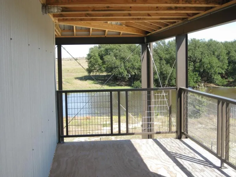 Upper deck with steel railing overlooking the water.