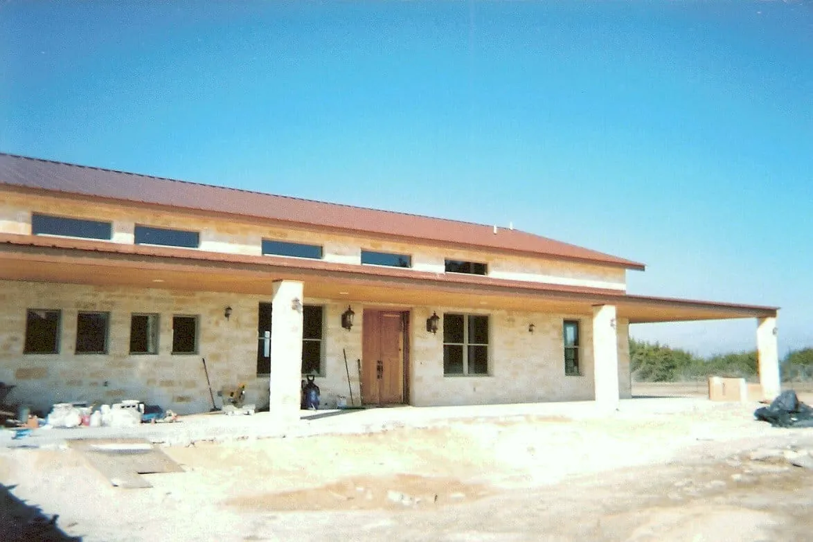 Stone ranch house nearing completion before final grading.