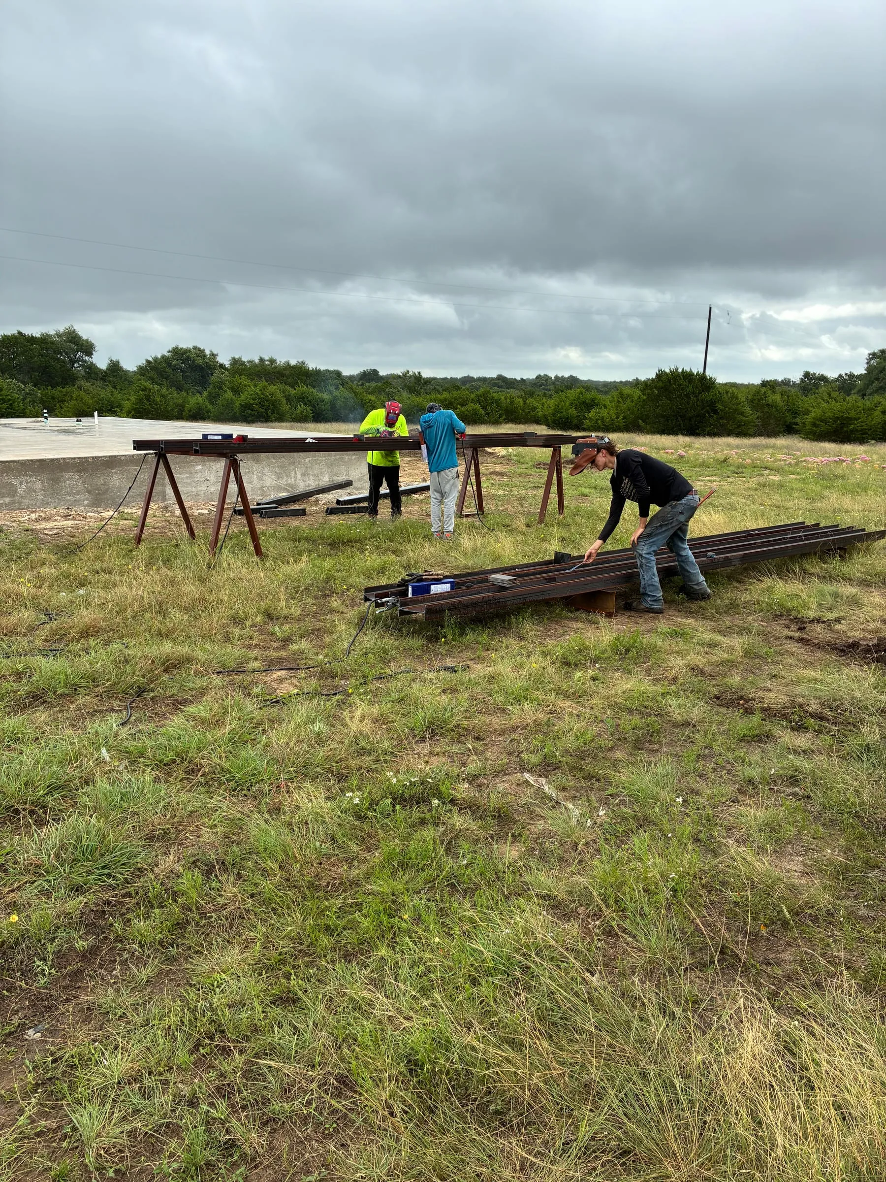 Crew members measure and prepare steel beams on the job site.