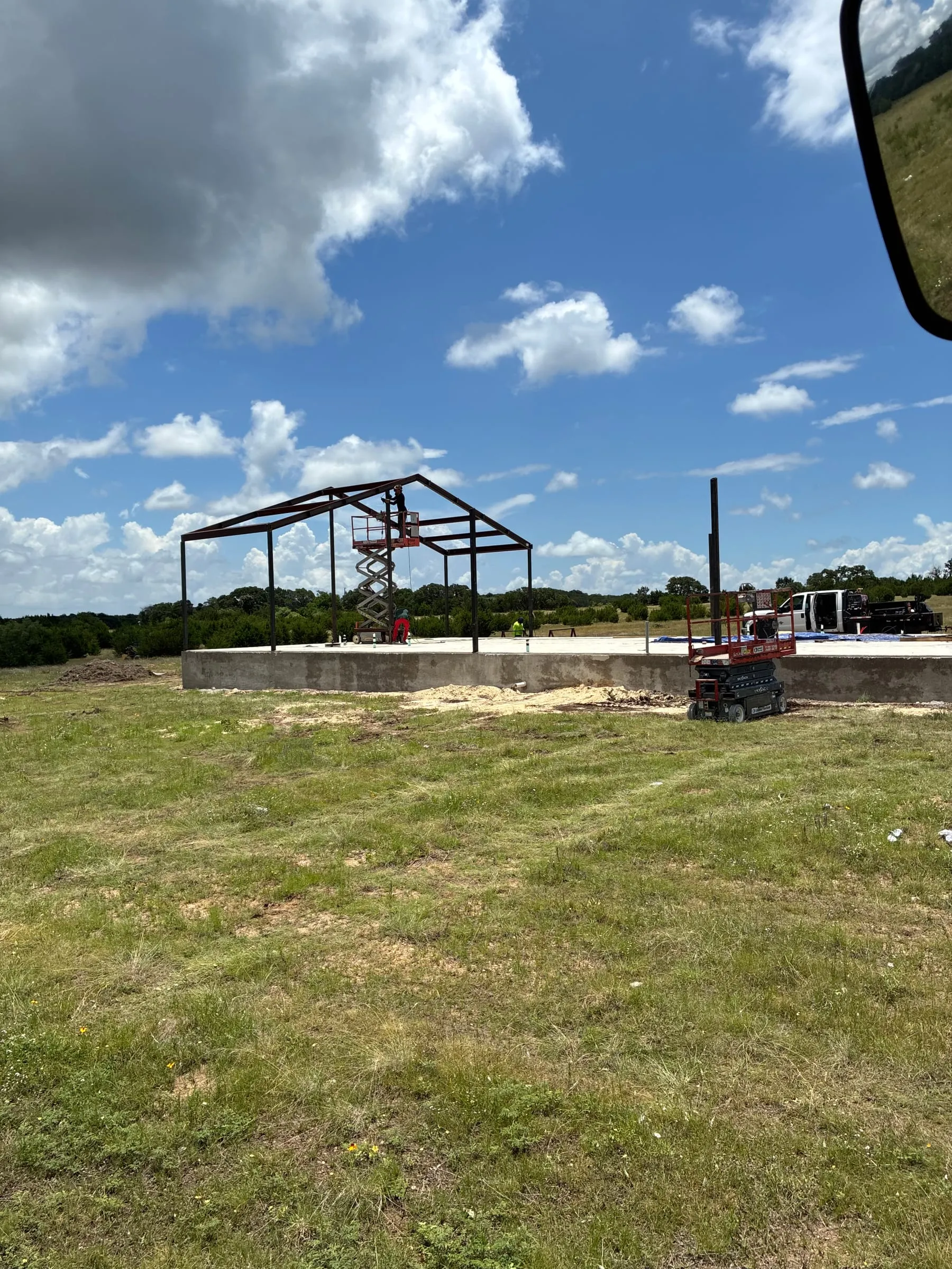 Early steel frame standing against a bright Central Texas sky.