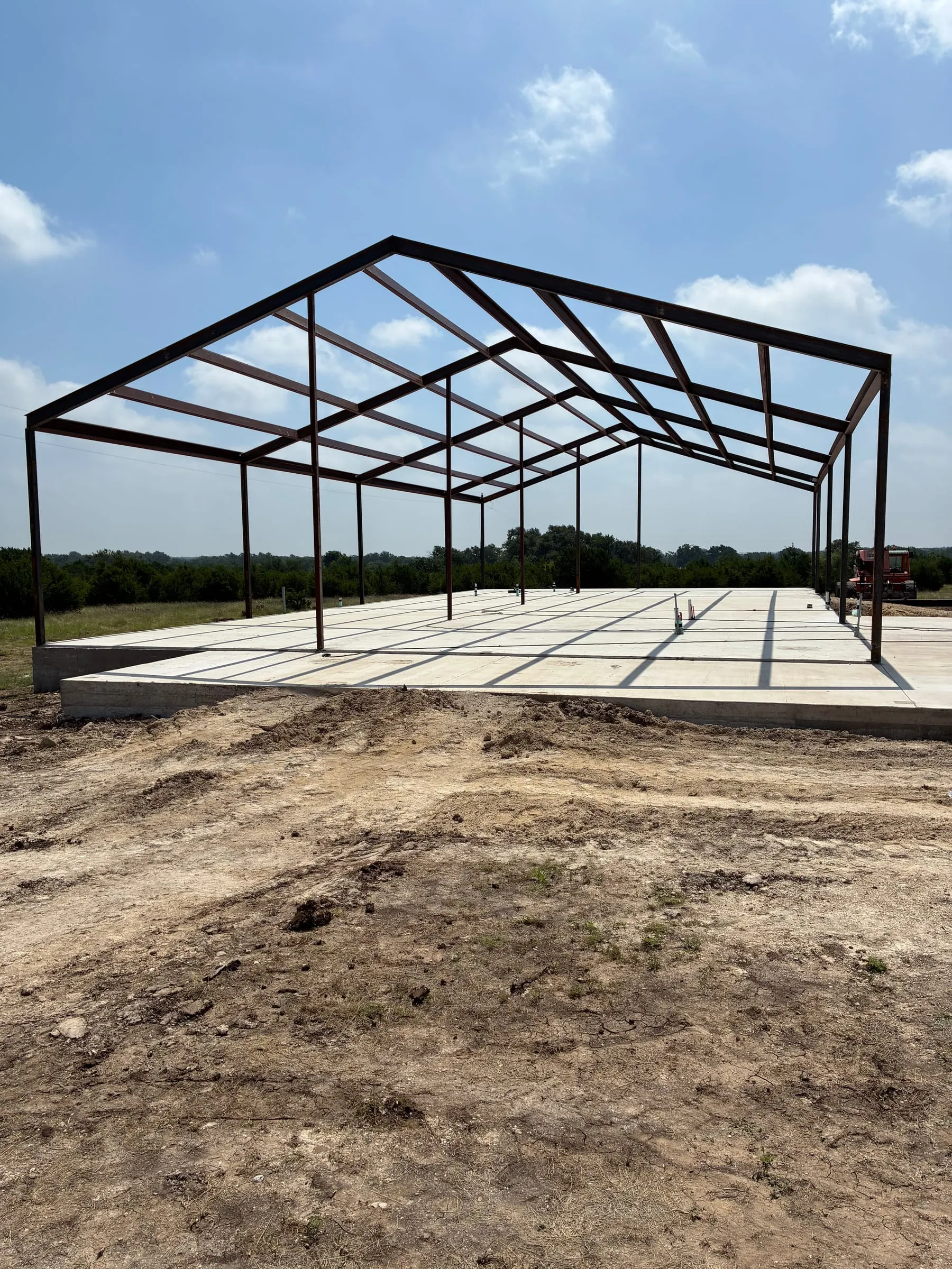 Wide steel frame for the Callaway two-garage home rising from the concrete slab.