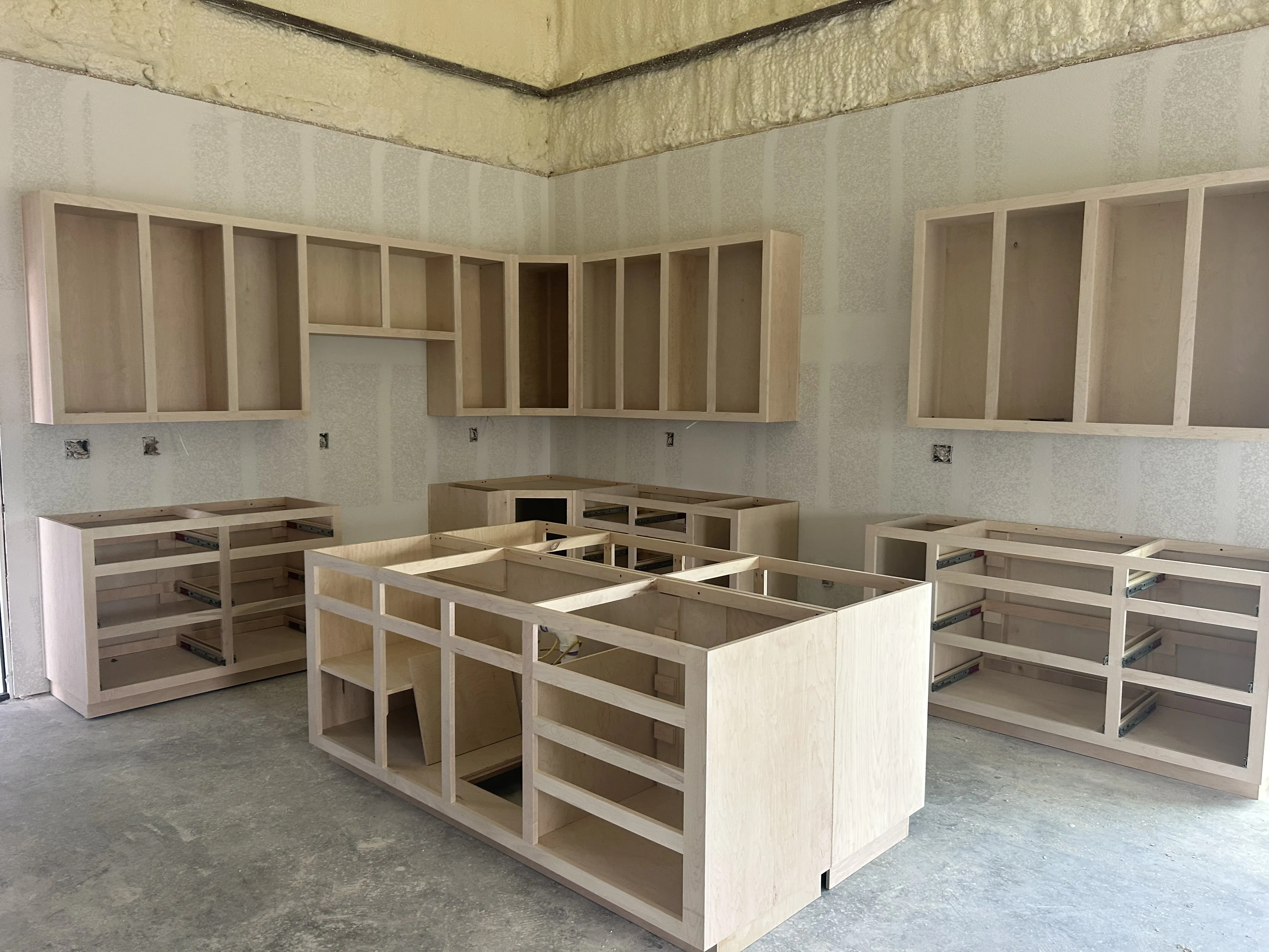 Custom kitchen cabinetry under construction inside the Liberty Hill barndominium.