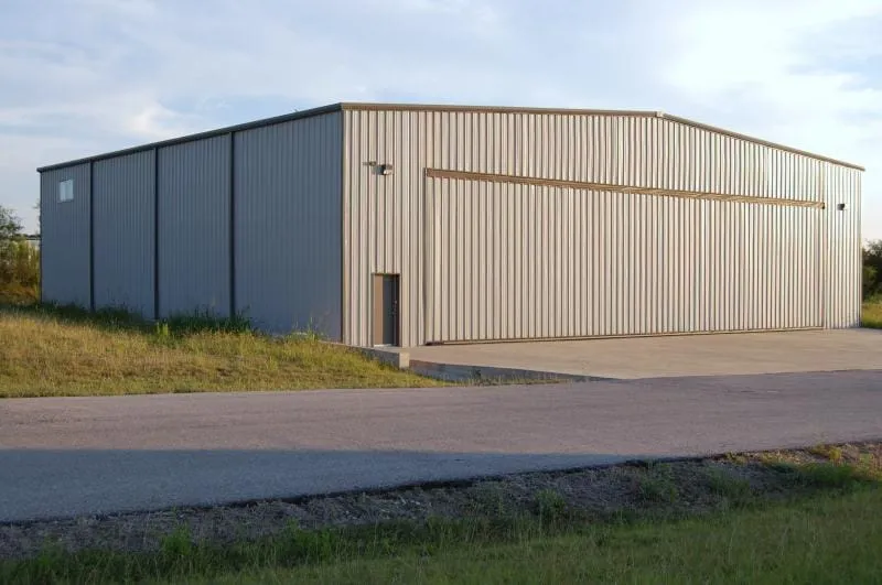 Tall clear-span steel hangar with oversized door opening.